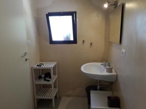 baño con lavabo y ventana en Casetta Vacanza in Campagna, en Aradeo