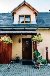 dom z brązowymi drzwiami i płotem w obiekcie Vilka Tkáč w mieście Kwaczany