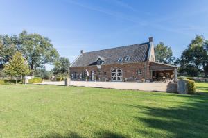 ein großes Backsteinhaus mit einem großen Rasenhof in der Unterkunft Spraelandhof in Oostrum