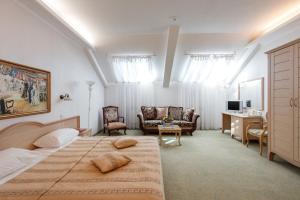 a bedroom with a large bed and a living room at Hermitage Hotel Rostov-on-Don in Rostov on Don