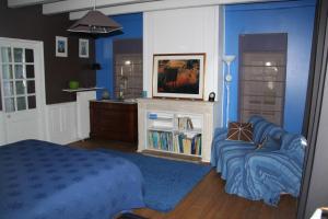 1 dormitorio con 1 cama, TV y sofá en Chambres d'hôtes Manoir du Buquet, en Honfleur