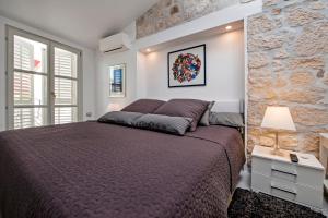 a bedroom with a large bed and a stone wall at Seaview House Rosali in Rovinj