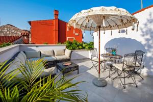a patio with a couch and an umbrella at Seaview House Rosali in Rovinj