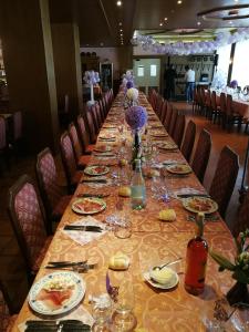 uma mesa longa com pratos de comida e copos de vinho em Hotel Dolomiti em Levico Terme