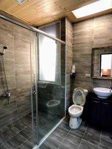 a bathroom with a shower and a toilet and a sink at Yellow Pui & Railway Inn in Jiji