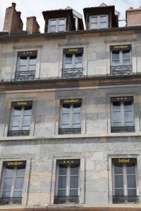 una fila de ventanas en un edificio de piedra en Hotel Vauban, en Besançon