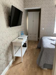 a bedroom with a bed and a desk with a tv on the wall at Rohuaia Apartments in Rakvere