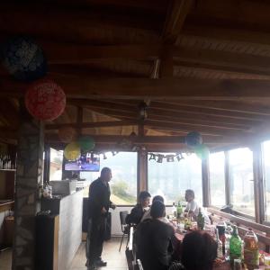 a group of people sitting at a table in a restaurant at Къща за гости Чала in Chala