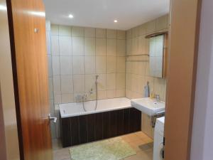 a bathroom with a bath tub and a sink at Ferienhaus Seeperle in Bodman-Ludwigshafen +23 photos