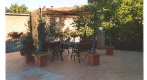 un patio con tavolo, sedie e piante di Il Grappolo a Mongardino