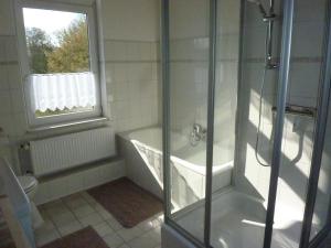 een badkamer met een douche en een bad bij Ehemaliges Waldkurhaus Drangstedt in Drangstedt