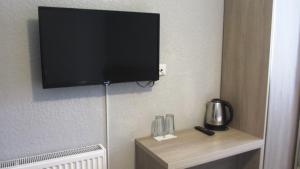 a flat screen tv hanging on a wall in a hotel room at Soncho Kazbegi in Stepantsminda