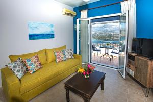 un salon avec un canapé jaune et une télévision dans l'établissement Antigone Apartments Argostoli (Spilia) 4, à Argostóli