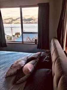 a bedroom with a large bed with a large window at Harbour Side Views in Dunedin