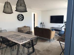 a living room with a table and a couch at LA POINTE D’ASPRETTO in Ajaccio