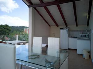 a kitchen with a glass table and white appliances at Villa Ujoli in Splitska