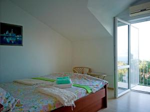 a bedroom with a bed and a large window at Villa Ujoli in Splitska