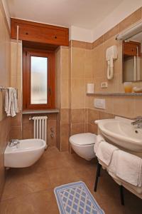 a bathroom with a sink and a tub and a toilet at Hotel Holiday Debili in Sauze dʼOulx