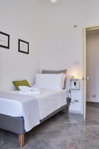 una camera da letto con un grande letto con lenzuola bianche di Dimora Casanello a Lecce