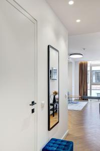 a hallway with a mirror and a blue stool at Downtown apartment in Vilnius str. in Vilnius