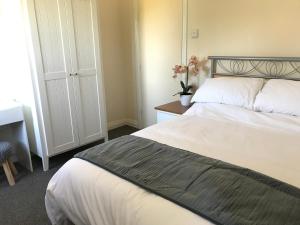 1 dormitorio con 1 cama y 1 mesa con flores en Moorhouse Farm Flat, en Telford