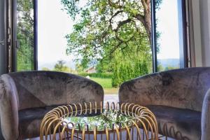 two chairs with a table in front of a window at House Klasika - Adults Only in Bled