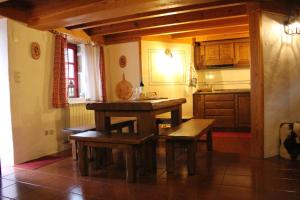 uma cozinha com uma mesa de madeira e bancos em Casa do Tio João em Seia