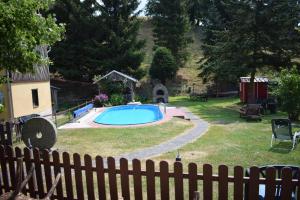 einen Hinterhof mit einem Pool und einem Zaun in der Unterkunft Ferienwohnung Waldmühle in Saupsdorf