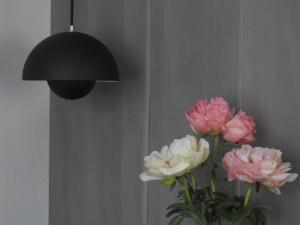 a vase with pink and white flowers next to a lamp at Hotel Garni Tannleger B&B in Brand