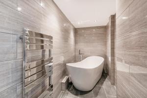 a bathroom with a white tub and a sink at Stylish 2 bedroom flat in Knightsbridge in London