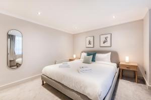 a bedroom with a large bed and a mirror at Stylish 2 bedroom flat in Knightsbridge in London