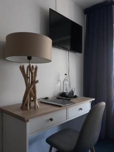 einen Schreibtisch mit einer Lampe und einem Stuhl in einem Zimmer in der Unterkunft Rathausschenke Münstermaifeld in Münstermaifeld