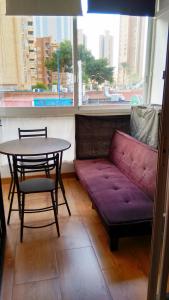a living room with a purple couch and a table at Precioso Apartment Lepanto-Levante in Benidorm