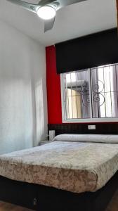 a bedroom with a bed with a red wall and a window at Precioso Apartment Lepanto-Levante in Benidorm +18 photos