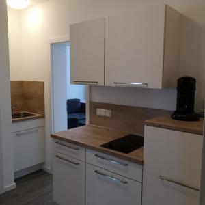 a kitchen with white cabinets and a sink at Haus Worch in Juist