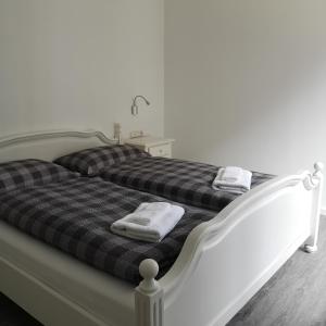 ein weißes Bett mit zwei Handtüchern darüber in der Unterkunft Haus Worch in Juist