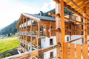 ein Holzhaus auf einem Feld im Bau in der Unterkunft Almfamilyhotel Scherer in Obertilliach