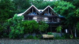 a wooden house with a bench in front of it at Villa Serena in Santo Domingo +7 photos