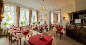a restaurant with tables and people sitting at tables at Hotel Seeufer in Plön