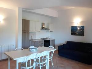 a kitchen and a living room with a table and chairs at Domus Liscia di Vacca in Liscia di Vacca