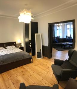 a bedroom with a bed and a couch and a mirror at Doma square apartment 2, in the heart of Old town in Riga