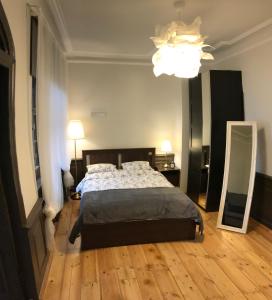 a bedroom with a bed and a mirror and a chandelier at Doma square apartment 2, in the heart of Old town in Riga