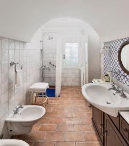- une salle de bains blanche avec deux lavabos et une douche dans l'établissement Il Cedrangolo House, à Monopoli
