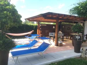 eine Terrasse mit blauen Liegestühlen und einem Grill in der Unterkunft Villa Margherita in Montaquila