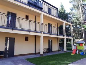 an apartment building with balconies and a yard at Dom Goscinny MARINERO in Pobierowo