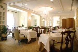 a restaurant with white tables and chairs and a chandelier at The Hay - Adams in Washington, D.C.