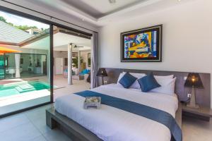 a bedroom with a large bed and a swimming pool at Villa Tropical Cocoon in Koh Samui 