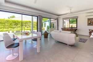 a living room with a white table and chairs at Villa Tropical Cocoon in Koh Samui 