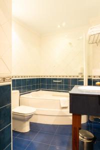 
a bathroom with a tub, toilet and sink at Gran Hotel Rural Cela in Belmonte de Miranda
