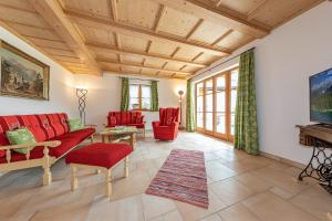 a living room with red furniture and a wooden ceiling at Ferienhaus 4erspitzblick in Mittenwald